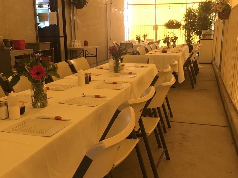 Patio banquet tables set with linens and flowers