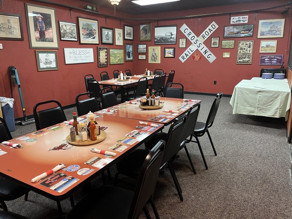 The indoor banquet room at The Red Caboose Café, tables set beneath framed railroad memorabilia